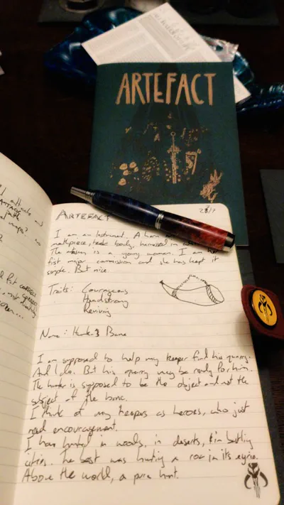 Notebook of handwritten scribbles and the green-and-gold ARTEFACT book