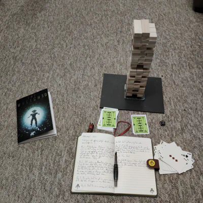 A jenga tower, the rpg book, cards, journal